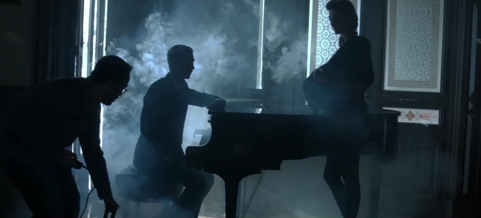 Pianista y actores a contraluz entre humo